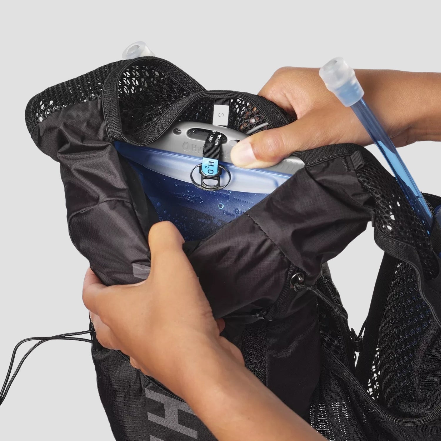 Detailed view of the HYDROFLOW water bladder included with the HLTHY AEROSKIN hydration running vest, featuring a durable design and convenient bite valve for easy hydration on the go
