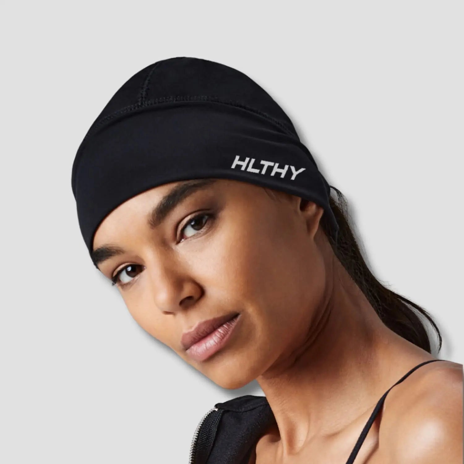 Runner wearing the HLTHY thermal running beanie during a chilly morning jog, highlighting its ability to retain heat and stay in place during movement